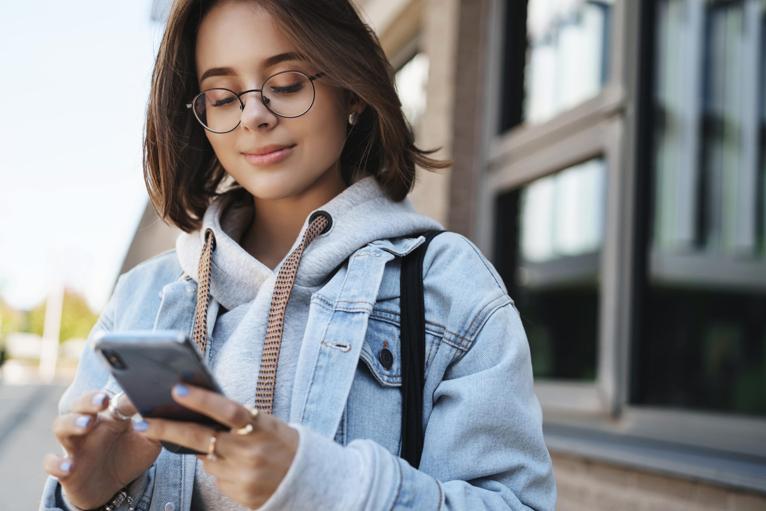 close-up-portrait-tender-romantic-girlfriend-send-cheerful-message-heart-emoji-friend-holding-mobile-phone-smiling-display-texting-with-friend-communicating-while-standing-street-min